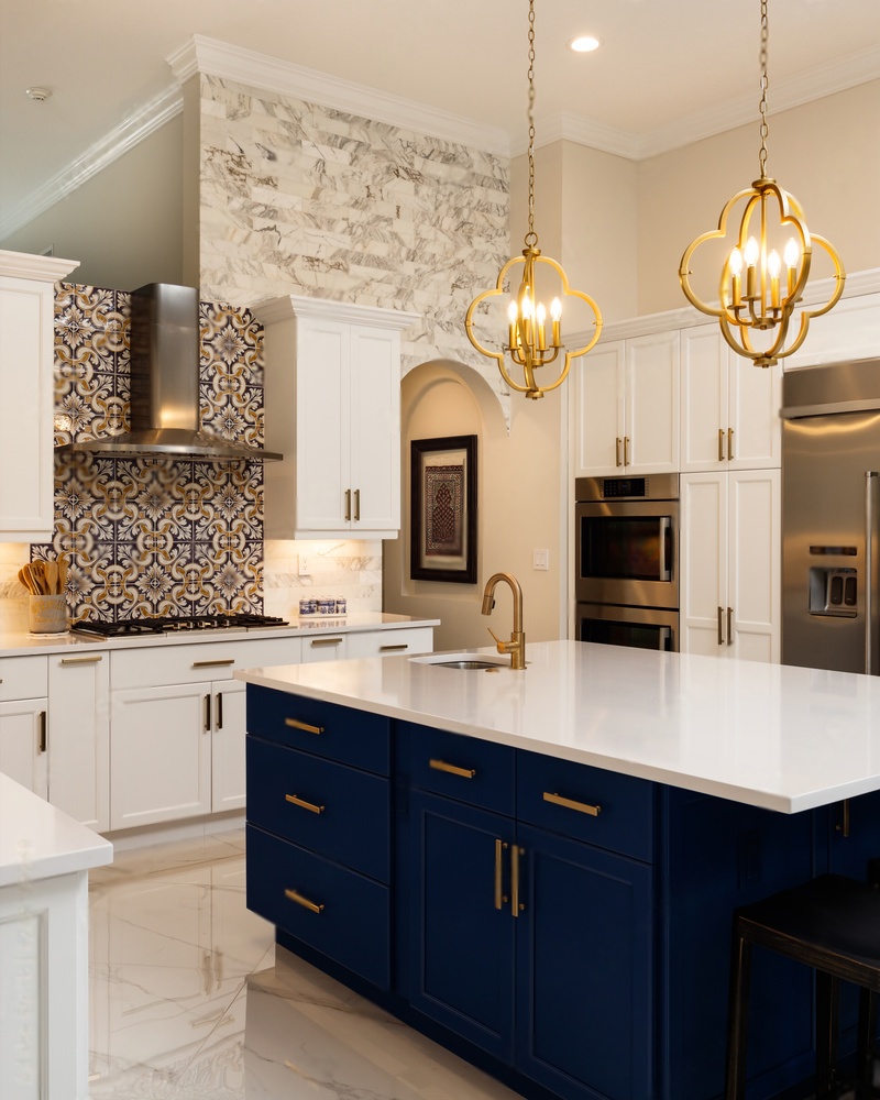Modern renovated kitchen with white cabinets, white countertops, and golden fixtures